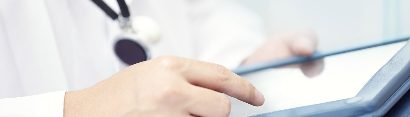 Hands of doctor indoors using tablet computer