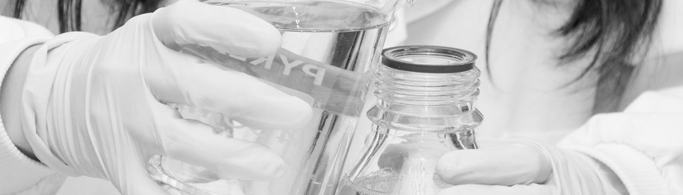 Researcher pouring suspension into a flask